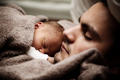 Dad and Kid Sleep Cuddling. [Sleep is essential for overall health and well-being.]
